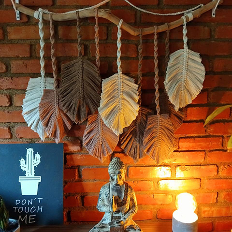 Painel de macramê de folhas penduradas no galho