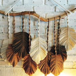 Painel de macramê de folhas penduradas no galho